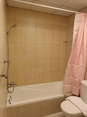 a bathroom with a pink shower curtain and a toilet at Modern Studio - Lincoln Park West - Dubai, Arjan in Dubai