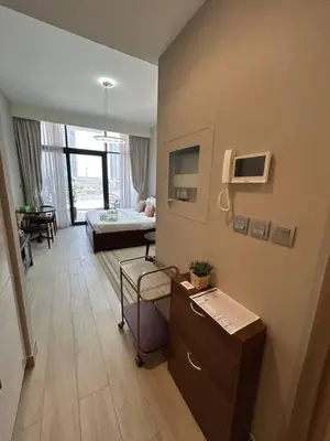 a living room with a couch and a table at Stylish Studio Retreat, Meydan Area and Pool Access in Dubai