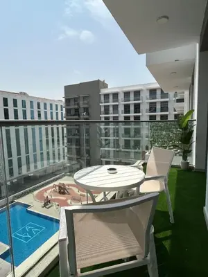 a balcony with a table and chairs and a pool at Stylish 1-Bed Apartment in Laya Heights, Dubai in Dubai