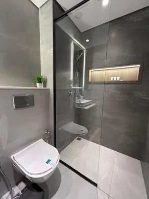 a bathroom with a toilet and a glass shower at Stylish 1-Bed Apartment in Laya Heights, Dubai in Dubai