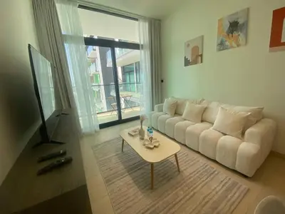 a living room with a white couch and a table at 1-Bedroom in Binghatti Emerald 1 with free Pool and Gym in Dubai