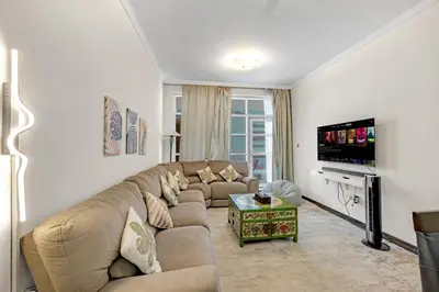 a living room with a couch and a tv at Luxury 2BR Escape - Durar 1B 2, Wadi Al Safa in Dubai