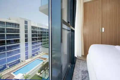 a hotel room with a view of a swimming pool at Chic Riviera 27 - 1BHK - Pool , Gym , Parking in Dubai