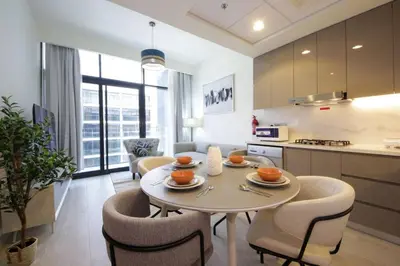 a kitchen and dining room with a table and chairs at Chic Riviera 27 - 1BHK - Pool , Gym , Parking in Dubai