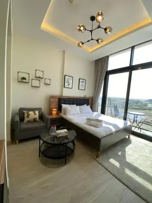 a bedroom with a bed and a couch and a table at Modern Studio in Azizi Riviera 10, Near Downtown in Dubai