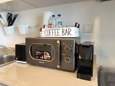 a microwave sitting on top of a kitchen counter at ASHRI HH | Elegant Studio | UNA Townsquare in Dubai