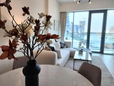 a vase with flowers on a table in a living room at SOLARTE Luxe - NEW Canal Front Residence - Pool with Burj Views in Dubai