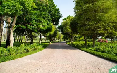 a brick road in a park with trees and bushes at SOLARTE Luxe - NEW Canal Front Residence - Pool with Burj Views in Dubai