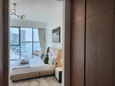a bedroom with a bed and a large window at SOLARTE Luxe - NEW Canal Front Residence - Pool with Burj Views in Dubai