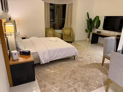 a bedroom with a bed and a living room at Stylish Studio in Business Bay Walking to Canal and Downtown in Dubai