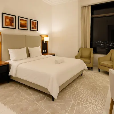 a bedroom with a large white bed and two chairs at Stylish Studio in Business Bay Walking to Canal and Downtown in Dubai