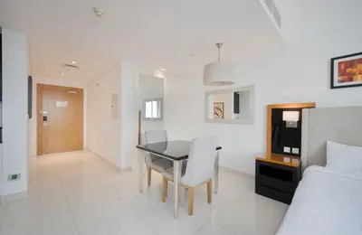 a bedroom with a dining room table and a bed at Stylish Studio in Business Bay Walking to Canal and Downtown in Dubai