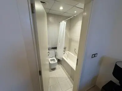 a bathroom with a toilet and a bath tub at Premium 1BR Apartment In Damac Ghalia with City View & Balcony in Dubai