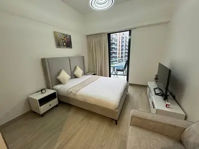 a bedroom with a bed and a tv and a couch at Azizi Riviera 41 - Meydan by Golden Casa in Dubai