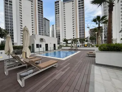 a swimming pool with chaise lounges and a swimming poolvisorvisorvisor at Azizi Riviera 41 - Meydan by Golden Casa in Dubai