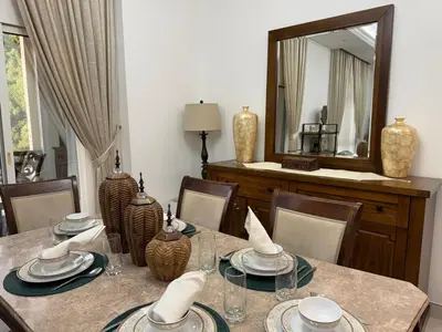 a dining room with a table and a mirror at Spacious 3BR Apartment Family Friendly Community in Dubai