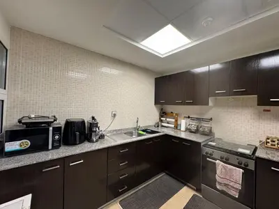 a kitchen with dark brown cabinets and a sink at Spacious 3BR Apartment Family Friendly Community in Dubai