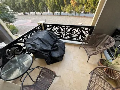 a balcony with a table and chairs and a black fence at Spacious 3BR Apartment Family Friendly Community in Dubai