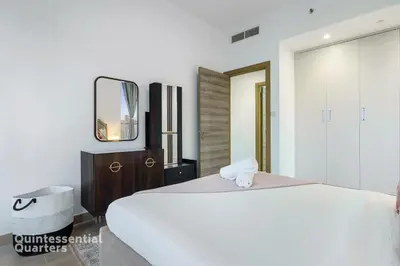 a bedroom with a white bed and a mirror at Stylish & Peaceful 2BR Home in JVC District in Dubai