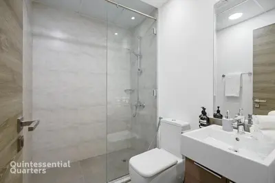 a bathroom with a shower and a toilet and a sink at Stylish & Peaceful 2BR Home in JVC District in Dubai