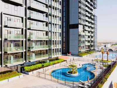 an apartment building with a pool in the middle at Stylish & Peaceful 2BR Home in JVC District in Dubai