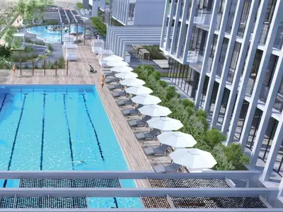 an overhead view of a swimming pool with umbrellas and chairs at Stylish & Peaceful 2BR Home in JVC District in Dubai