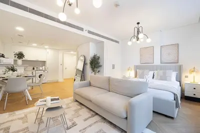 a white bedroom with a bed and a couch at DIFC Sky Gardens Studio In front of DIFC Gate in Dubai