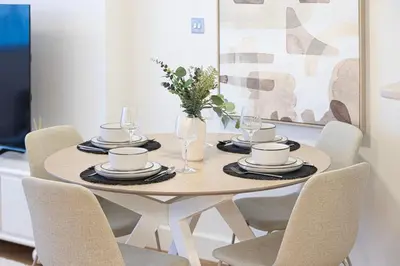 a dining room table with chairs and a table with cups and plates at DIFC Sky Gardens Studio In front of DIFC Gate in Dubai