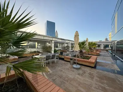 a rooftop patio with a table and chairs and an umbrella at DIFC Sky Gardens Studio In front of DIFC Gate in Dubai