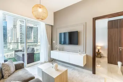 a living room with a couch and a tv at RH - Burj Khalifa view with large balcony, 02BR retreat in business bay in Dubai
