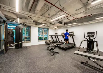 a man running on a treadmill in a gym at Vacay Lettings 1 bed with burj Khalifa View in Dubai