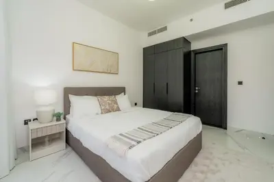 a bedroom with a large bed and a black cabinet at Gardenia Living 204 in Dubai