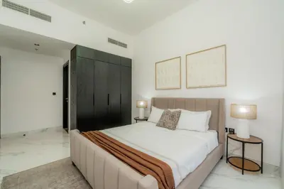 a bedroom with a large bed and two tables at Gardenia Living 204 in Dubai