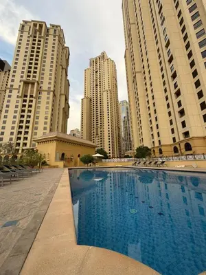 a large swimming pool in a city with tall buildings at 2 Massage Chairs Marina View 2 Bedrooms in Dubai