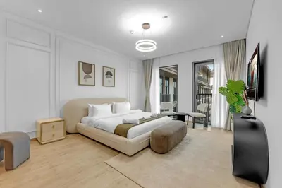 a white bedroom with a bed and a table at Gym, Spa & Sauna, Pool, Tenis Court, Dishwasher, 2BR in Central Park in Dubai