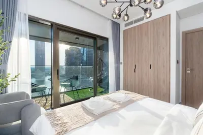a bedroom with a bed and a large window at Modern 1BR Canal View Pool View in Dubai