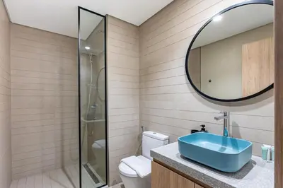 a bathroom with a blue sink and a mirror at Modern 1BR Canal View Pool View in Dubai