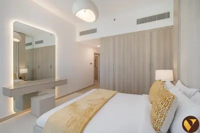 a bedroom with a white bed and a large mirror at Vogue JVC Jeewar Tower Near Circle Mall, One Bedroom Apartment with Balcony and City View, Access to all Amenities in Dubai