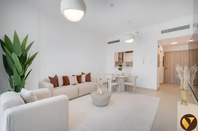a white living room with a couch and a table at Vogue JVC Jeewar Tower Near Circle Mall, One Bedroom Apartment with Balcony and City View, Access to all Amenities in Dubai