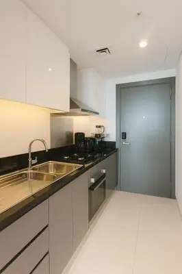 a kitchen with a sink and a stainless steel door at Opulent Suites - Business Bay - Downtown in Dubai