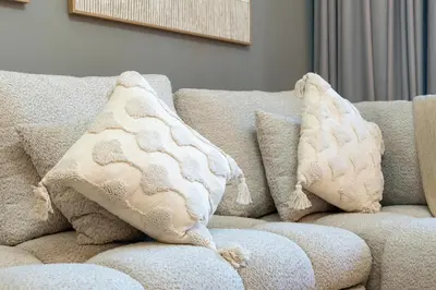 a couch with pillows on it in a living room at Stylish 1BR Canal & Burj View High Floor in Dubai