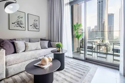 a living room with a couch and a large window at Frank Porter - Peninsula One in Dubai