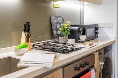 a kitchen counter with a stove and a microwave at Frank Porter - Peninsula One in Dubai