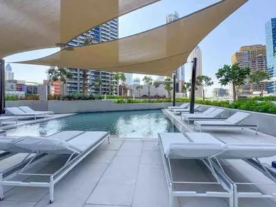 a pool with chaise lounge chairs and a swimming pool at Frank Porter - Peninsula One in Dubai