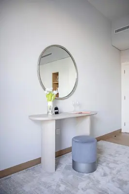 a dressing table with a mirror and a blue stool at Frank Porter - La Voile in Dubai