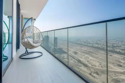a wicker chair sitting on a balcony with a view at Frank Porter - Binghatti Onyx in Dubai