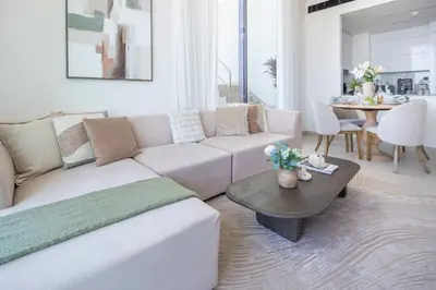 a living room with a white couch and a table at Frank Porter - Binghatti Onyx in Dubai