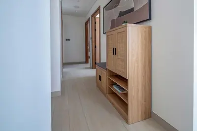 a hallway with a wooden cabinet in a house at Frank Porter - Binghatti Onyx in Dubai