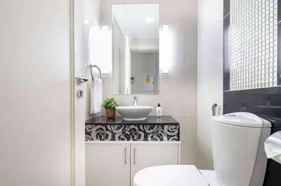 a white bathroom with a sink and a mirror at Frank Porter - The Signature in Dubai