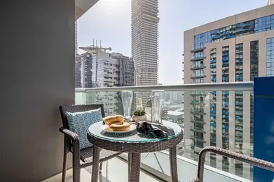 a table and chairs on a balcony with a view of a city at Frank Porter - The Signature in Dubai